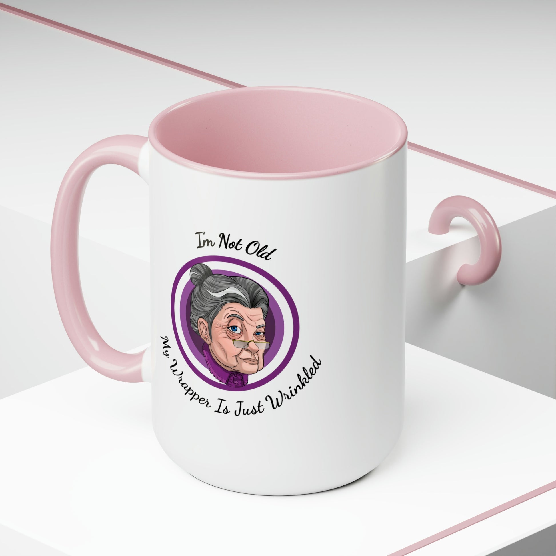 pink two tone coffee mug with purple logo saying I'm not old my wrapper is just wrinkled